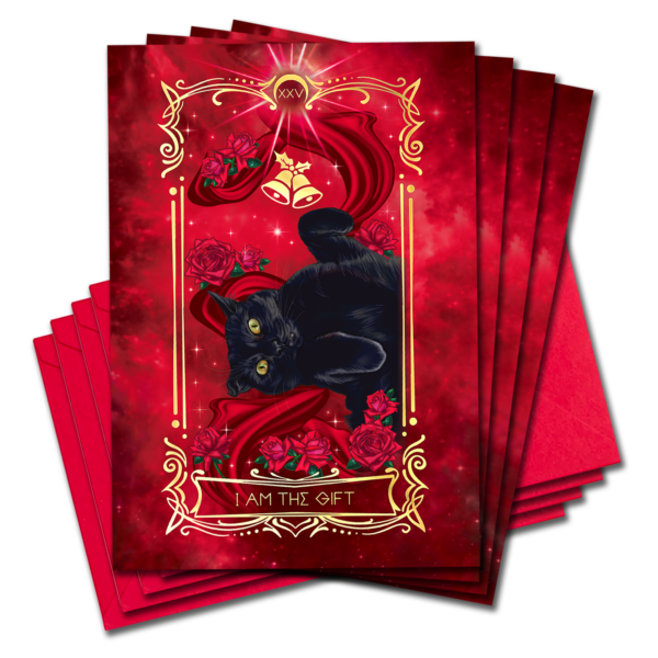 Black cat with curly paws lies on bed of satin and roses, gold bells above him. Text reads "I am the Gift"
